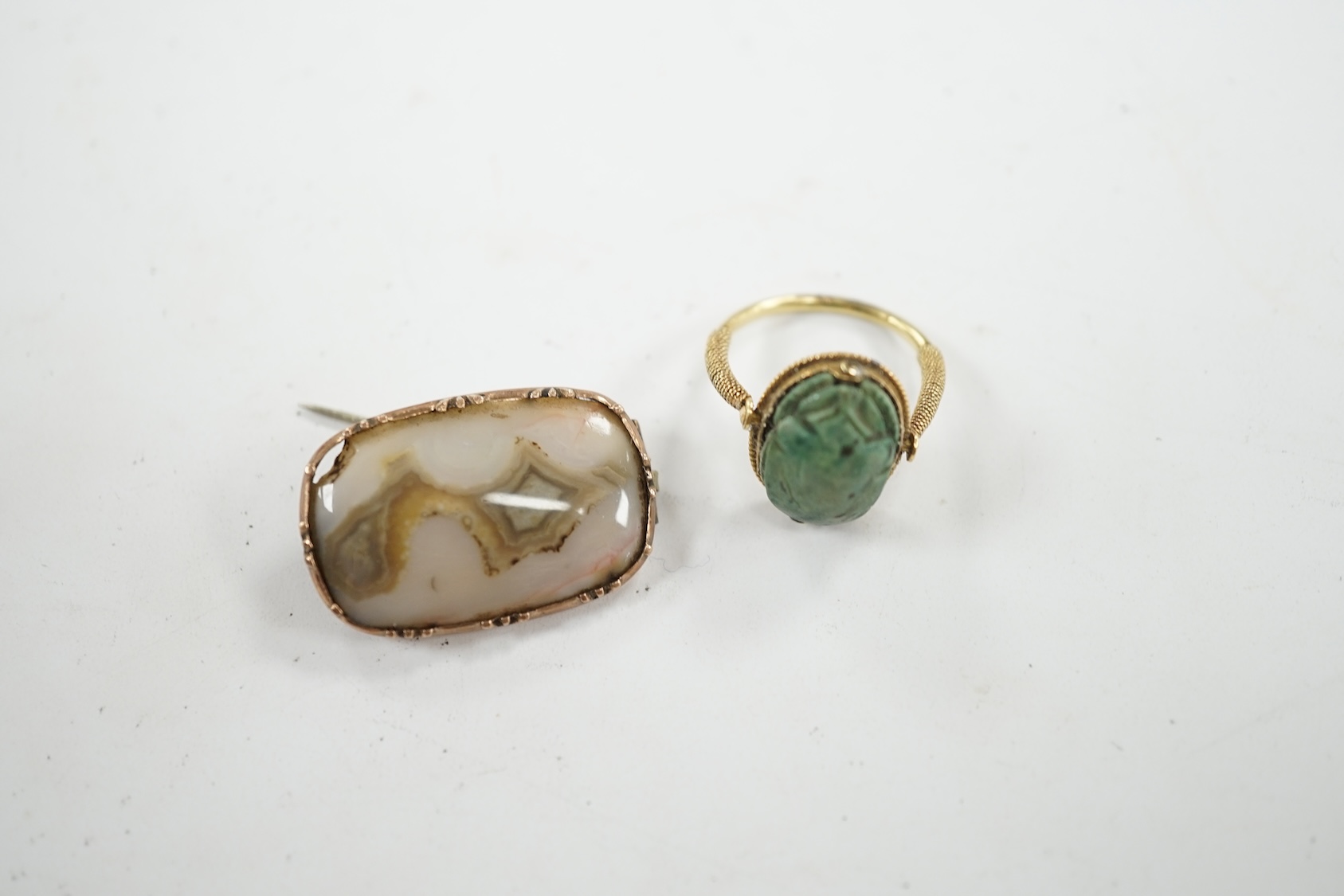 An antique yellow metal 'Scarab' ring and a banded agate set brooch. Condition - poor to fair